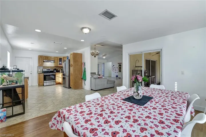 Dining area with hanging lights and light wood-type flooring