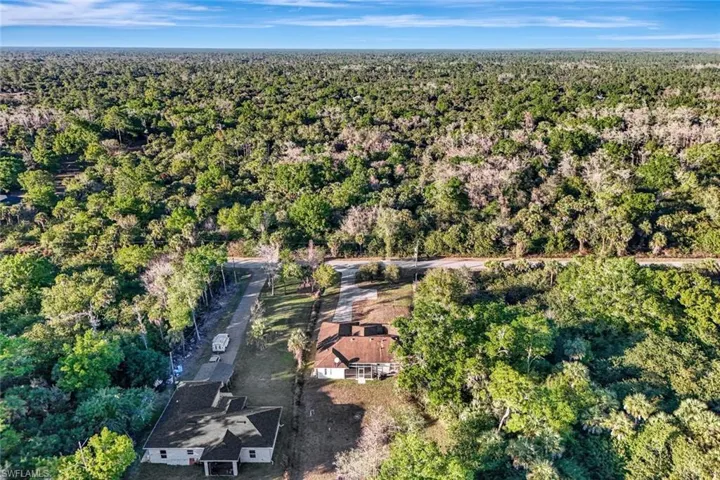 Aerial view of property's location with a forest