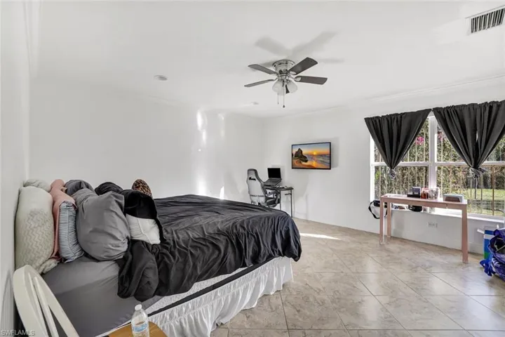 Bedroom featuring crown molding, ceiling fan, and a desk