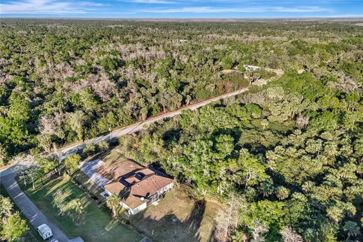 Aerial view of property's location featuring a forest