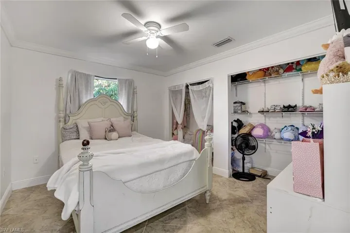 Bedroom with ceiling fan and crown molding