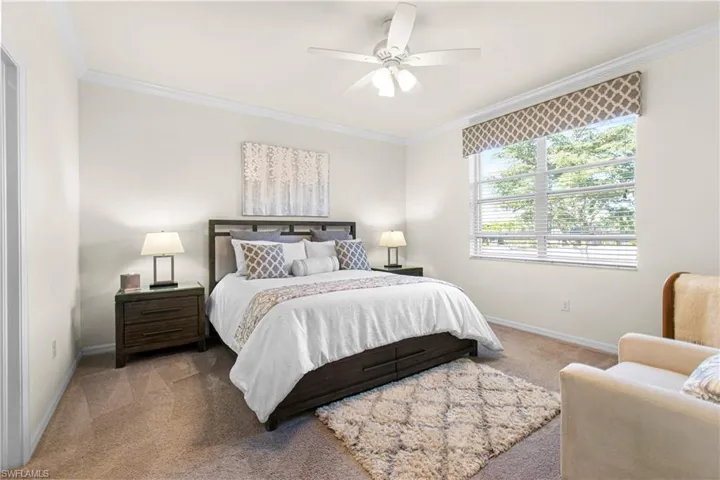 Main Carpeted bedroom with crown molding and a ceiling fan