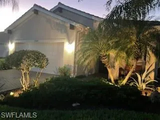 View of side of home with stucco siding, a garage, and driveway