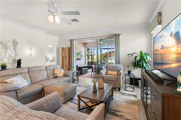Living area featuring ornamental molding and a ceiling fan