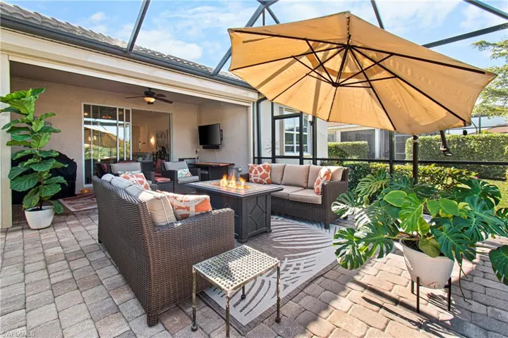 View of patio / terrace with an outdoor living space with a fire pit, a sunroom, a lanai, and ceiling fan