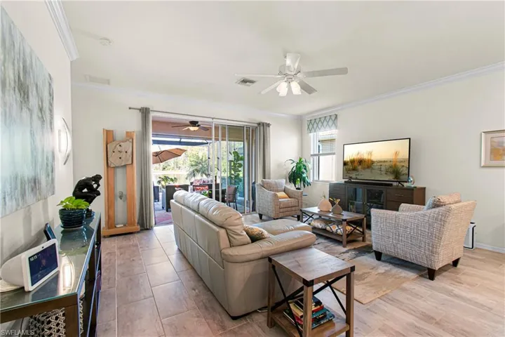 Living area with crown molding and a ceiling fan