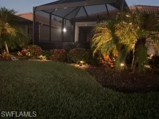 View of green lawn featuring glass enclosure and a sunroom