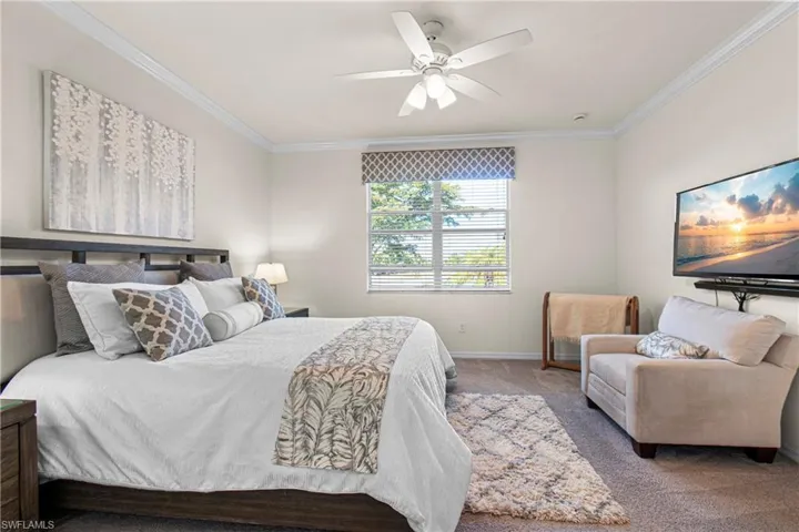 Main Bedroom with ornamental molding, carpet flooring, and a ceiling fan