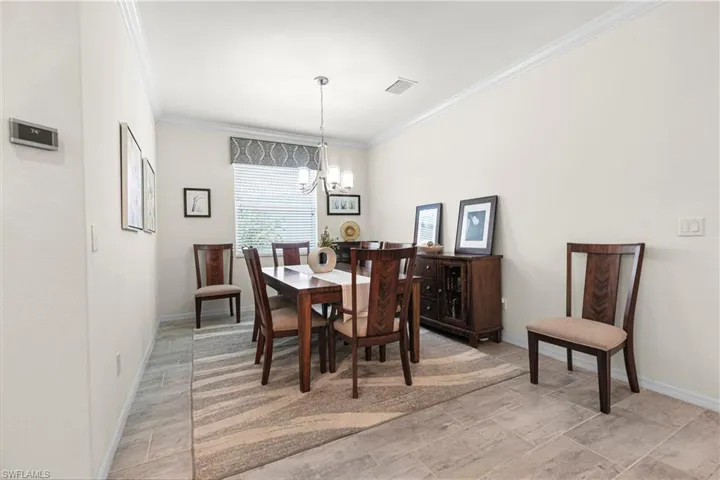 Dining area with a chandelier and crown molding