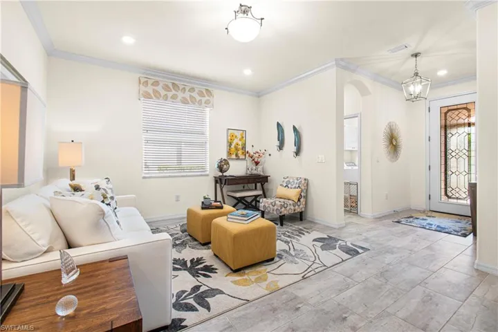 Living room featuring arched walkways, crown molding, healthy amount of natural light, and recessed lighting