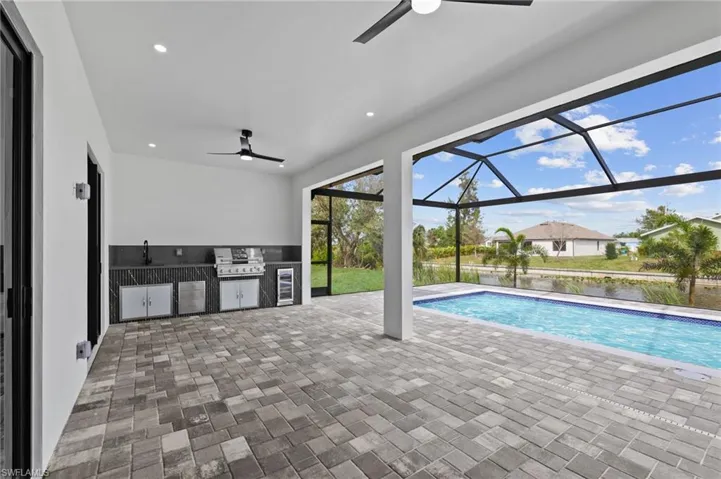 View of swimming pool featuring area for grilling, a sink, and a ceiling fan