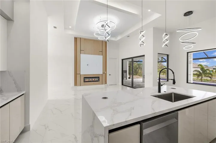 Kitchen with a tray ceiling, marble finish floor, a sink, and modern cabinets