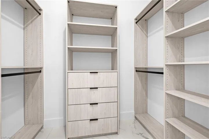 Walk in closet featuring marble finish floor