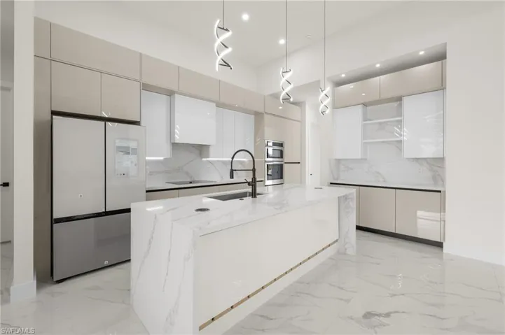 Kitchen with marble finish floor, modern cabinets, and freestanding refrigerator