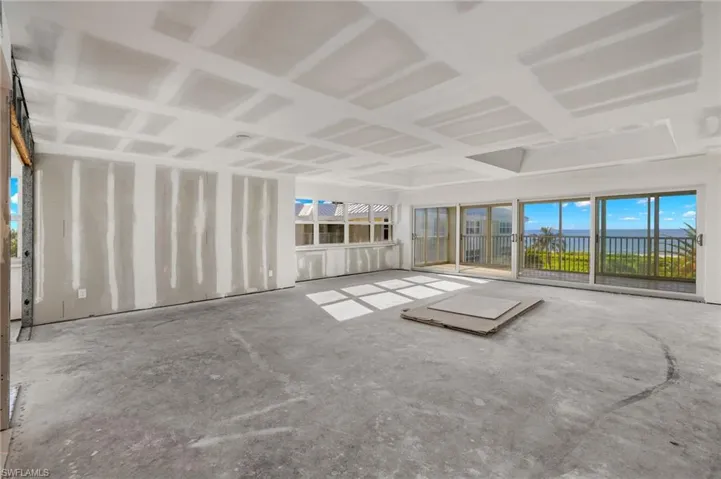 Unfurnished living room with concrete flooring and a water view