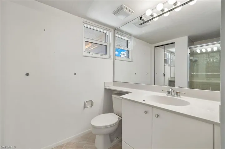 Bathroom featuring vanity, toilet, and tile patterned floors
