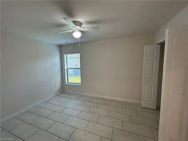 Unfurnished room featuring light tile patterned floors and ceiling fan