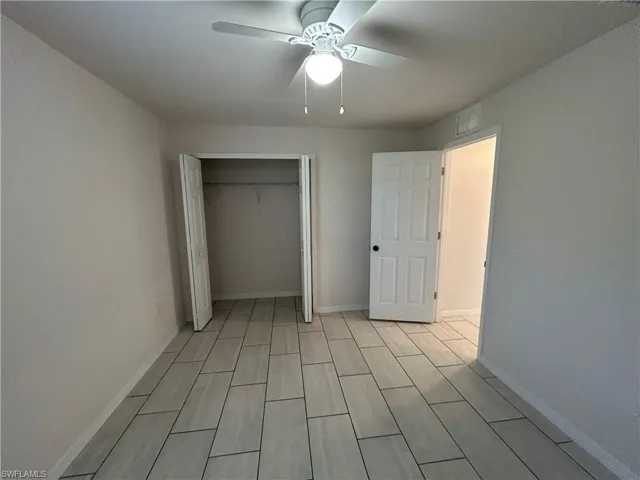 Unfurnished bedroom with a closet, a ceiling fan, and wood finish floors