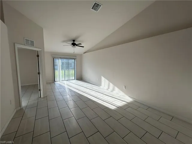 Unfurnished room featuring lofted ceiling and a ceiling fan