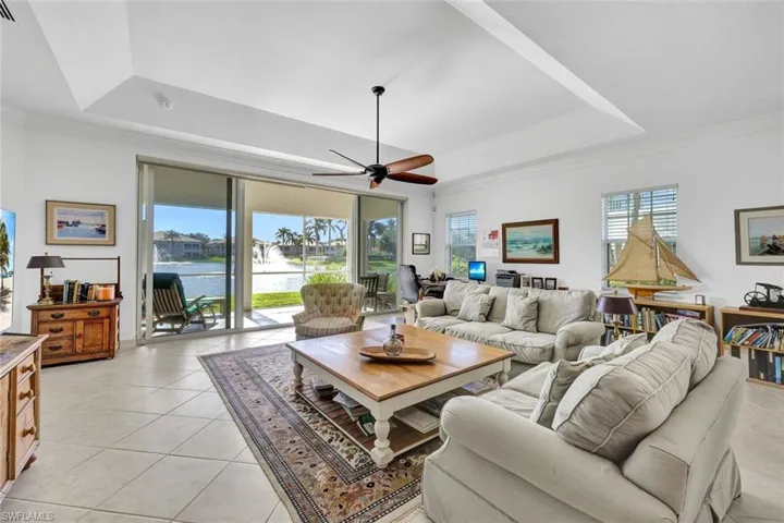 Living room with a healthy amount of sunlight, a water view, and a tray ceiling