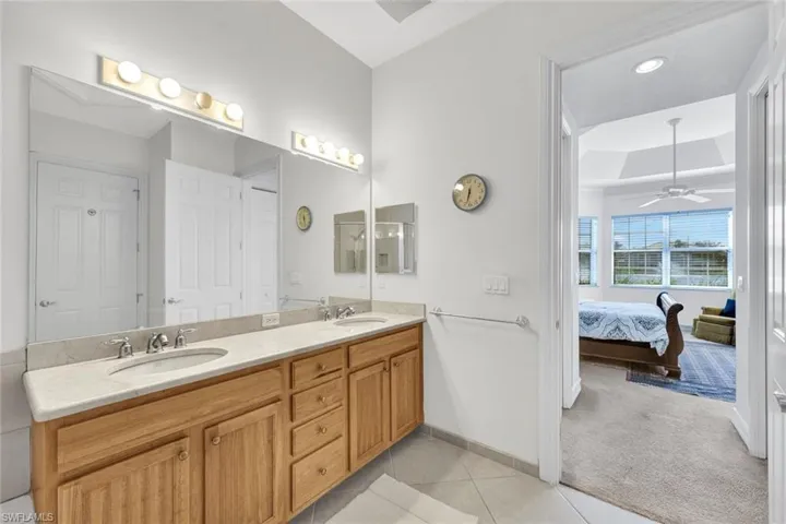 Bathroom with tile patterned floors, ceiling fan, and vanity