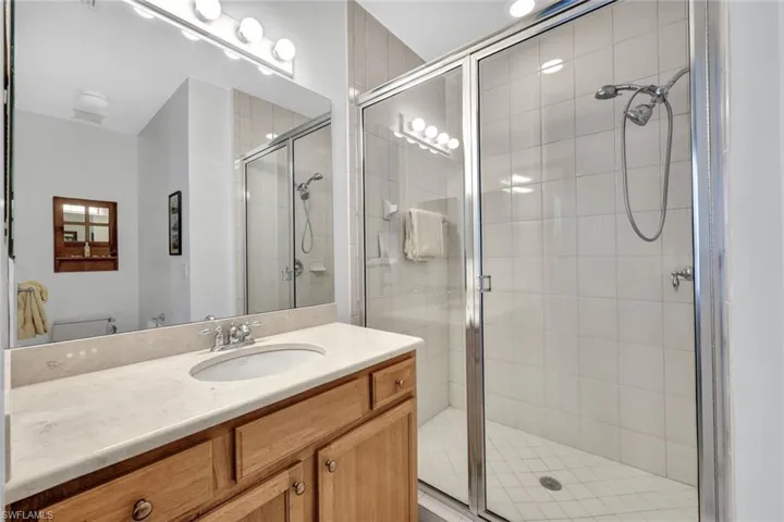 Bathroom featuring vanity, toilet, and a shower with door