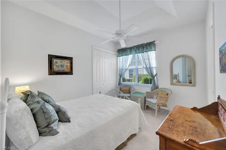 Carpeted bedroom featuring ceiling fan and a closet