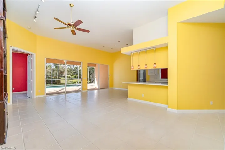 Unfurnished living room with rail lighting, light tile patterned flooring, and ceiling fan