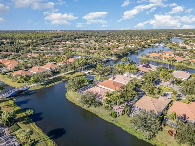 Aerial view of property and surrounding area featuring nearby suburban area and a nearby body of water