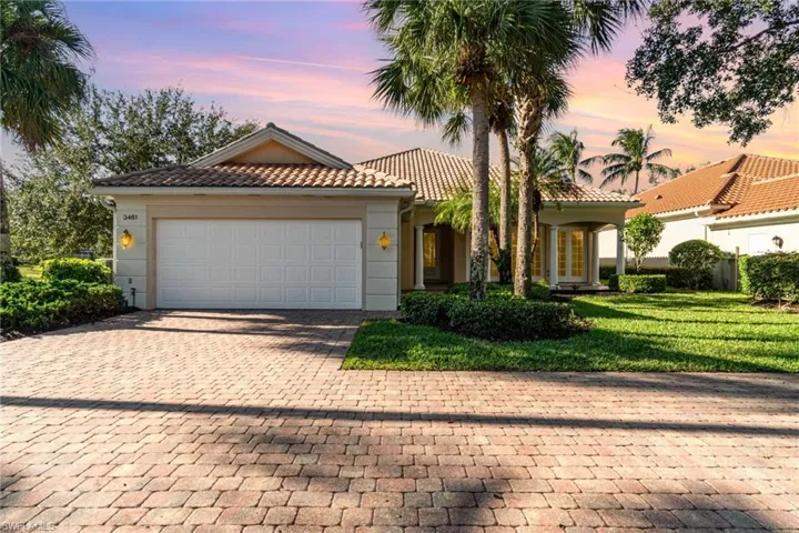 Mediterranean / spanish-style home with decorative driveway, a garage, a yard, and a tile roof