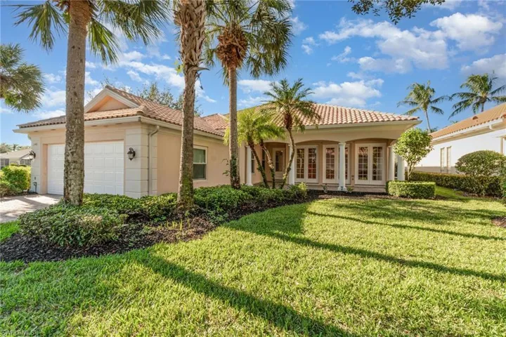 View of front of property with a garage, a front yard, stucco siding, a tile roof, and french doors