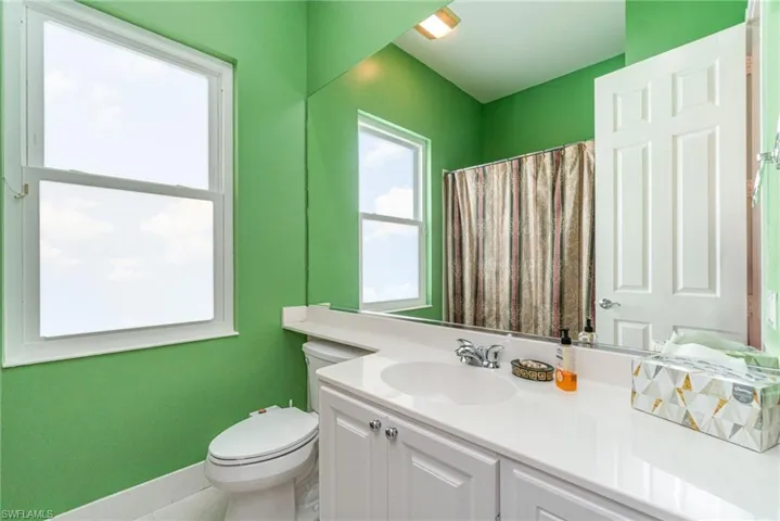 Full bathroom featuring a shower with shower curtain, vanity, and tile patterned flooring
