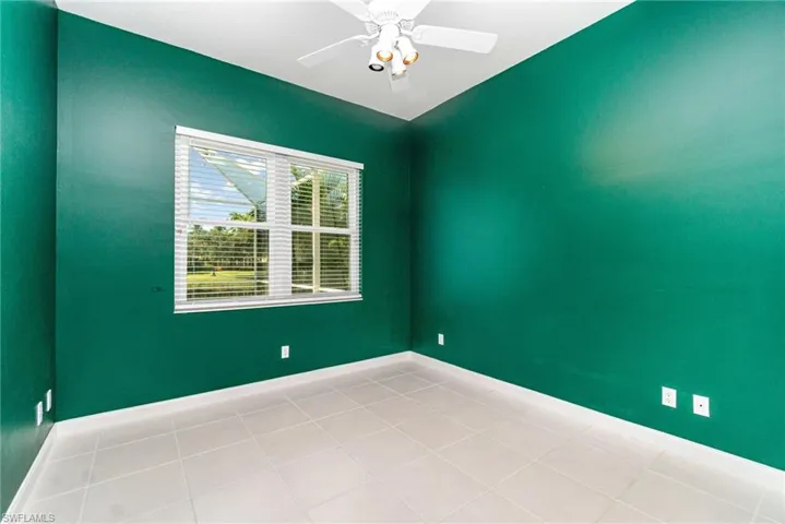 Spare room with light tile patterned flooring and a ceiling fan