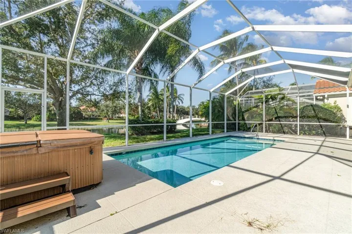 Outdoor pool with a sunroom, a lanai, a patio, and a hot tub