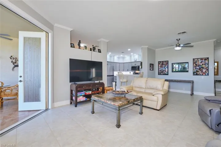 Living area featuring ornamental molding, ceiling fan, light tile patterned floors, and recessed lighting