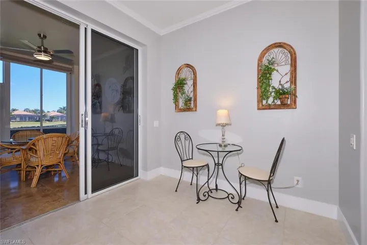 Sitting room with crown molding, a ceiling fan, and tile patterned flooring