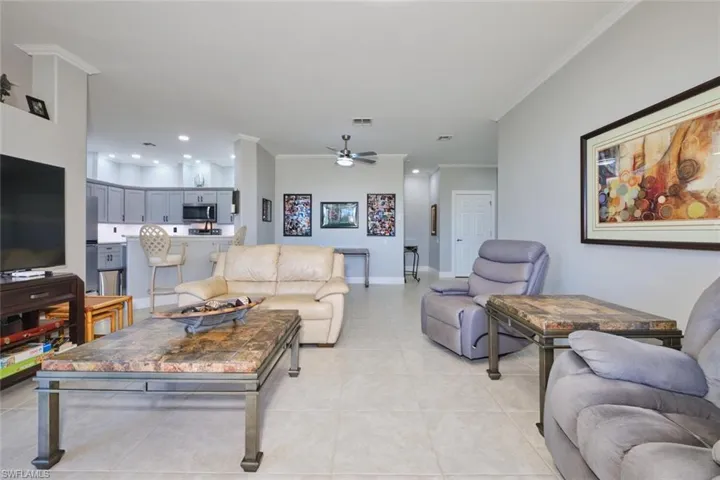 Living area featuring ornamental molding, ceiling fan, recessed lighting, and light tile patterned floors