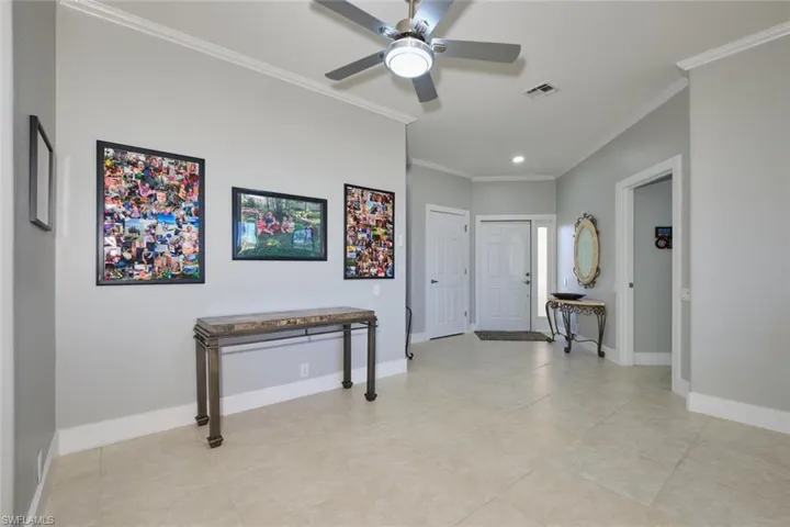 Entryway featuring ornamental molding and light tile patterned floors