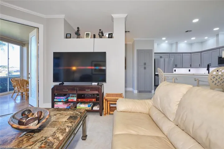 Living area with crown molding, recessed lighting, and light tile patterned flooring