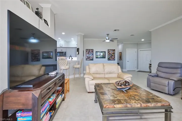 Living area featuring ceiling fan, crown molding, and recessed lighting