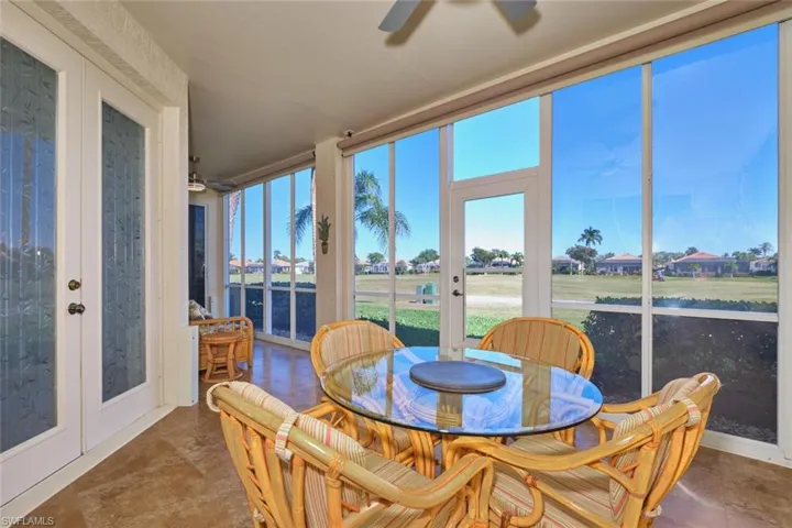 Sunroom / solarium featuring french doors, a residential view, and a water view
