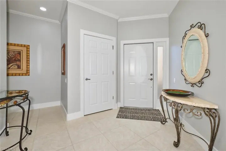 Entryway featuring crown molding, light tile patterned flooring, and recessed lighting