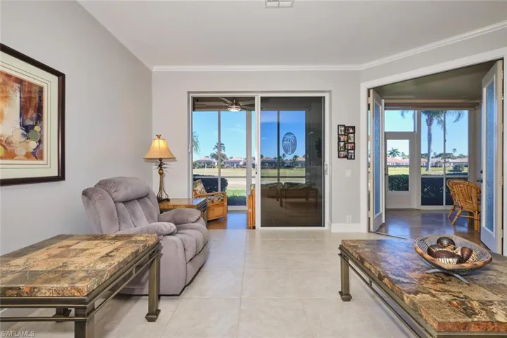 Living room featuring healthy amount of natural light, ornamental molding, and tile patterned flooring