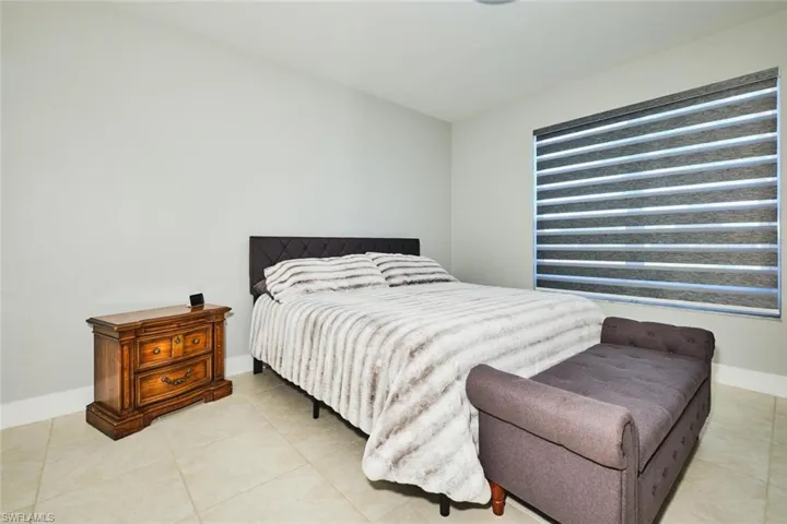 Bedroom featuring baseboards and light tile patterned flooring