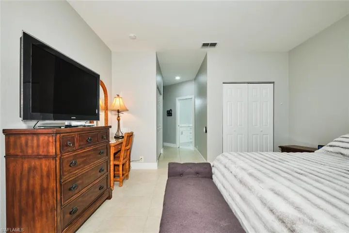 Bedroom featuring ensuite bathroom and light tile patterned floors