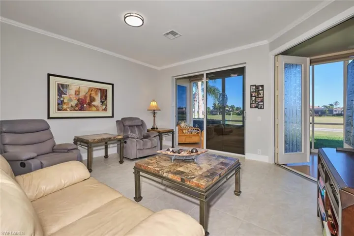 Living area featuring ornamental molding and light tile patterned floors