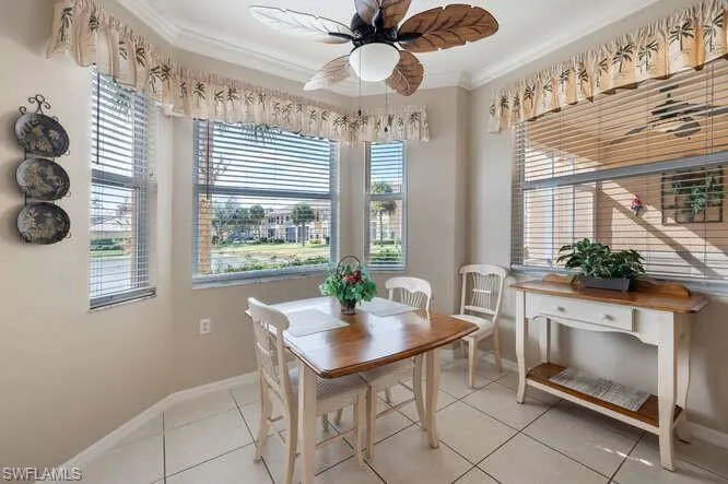 Tiled dining room with crown molding and ceiling fan