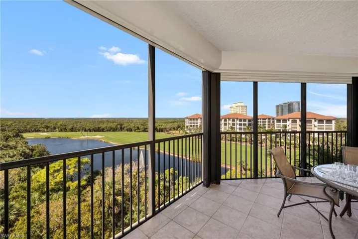 Balcony featuring a golf course & water view