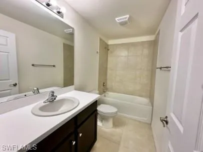 Bathroom featuring a dark wood-finish vanity, white countertop, and integrated oval sink