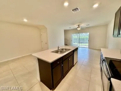 Kitchen island featuring a double-basin sink and integrated dishwasher